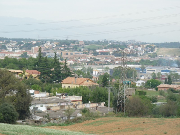 En primer terme, vista parcial de Can Parera, amb part de la resta del municipi al fons