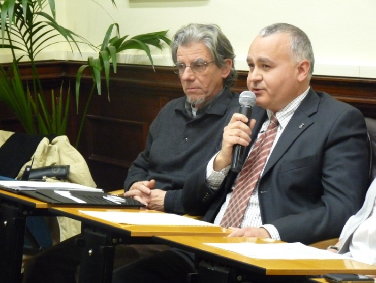El regidor Jaume Oliveras (parlant al micròfon) al Ple, al costat del regidor Miquel Truyols