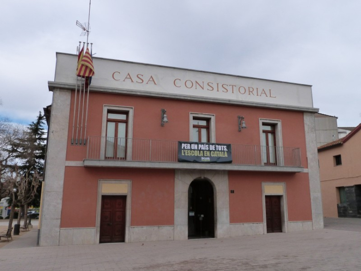 La façana de la Casa Consistorial amb la pancarta de Som Escola