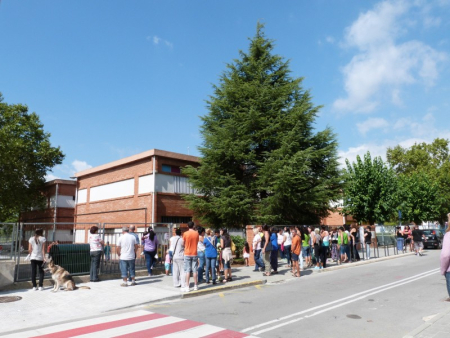 Familiars dels alumnes els esperen a les portes de l'Escola Josep M. Folch i Torres en acabar les classes del matí del primer dia de curs
