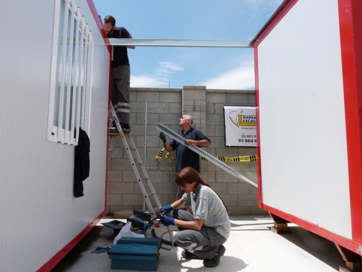 Sílvia, oficial electricista, treballant en els mòduls que s'instal·len al camp de futbol amb part de l'equip de brigades d'electricitat de l'Ajuntament.