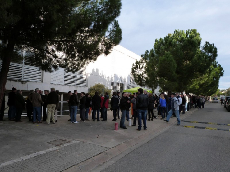 Desenes de persones fent cua abas que s'obrís el punt de participació del 9N.
